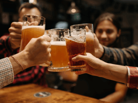 pints of beer clinking together in a pub setting